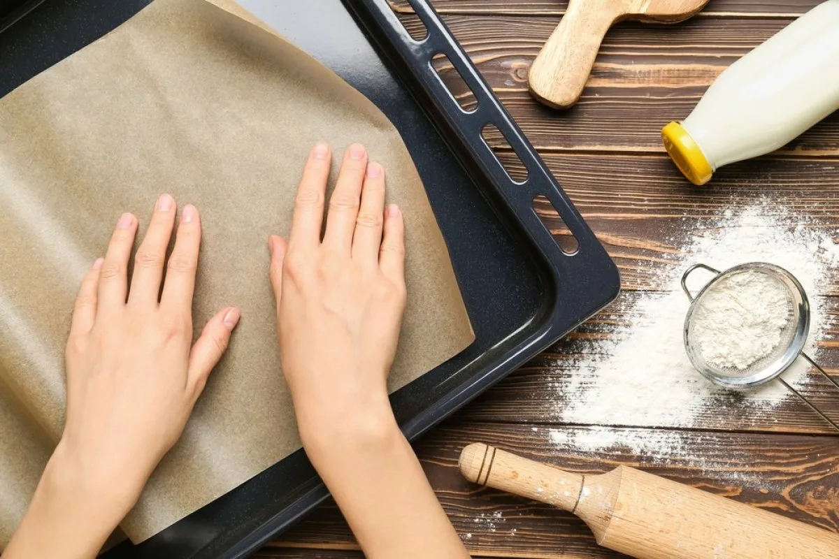 coloca el papel de hornear con el lado correcto hacia arriba en la bandeja del horno