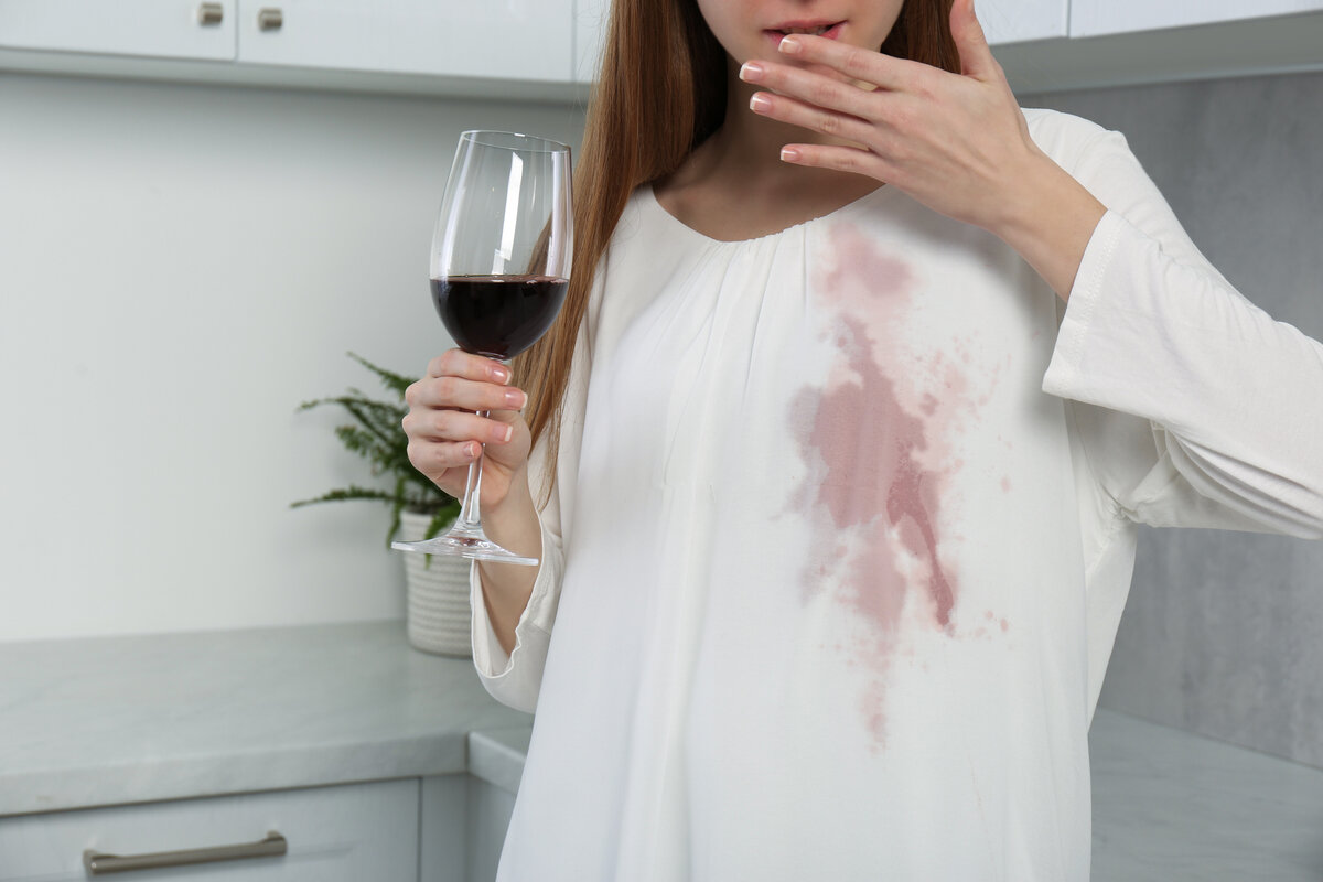 La chica derramó vino sobre su blusa blanca
